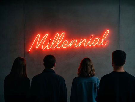 Visitatori osservano una scritta al neon rossa, ‘Millennial’, installata su un muro grigio in uno spazio espositivo, simbolo della generazione analizzata nel post