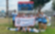 Youth softball team posing on field with championship banner; scoreboard behind them at POST park, smiling and celebrating.