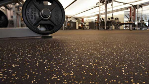 A gym floor featuring rubber rolls highlighted with sparkling gold glitter, enhancing the space's energy and visual appeal.