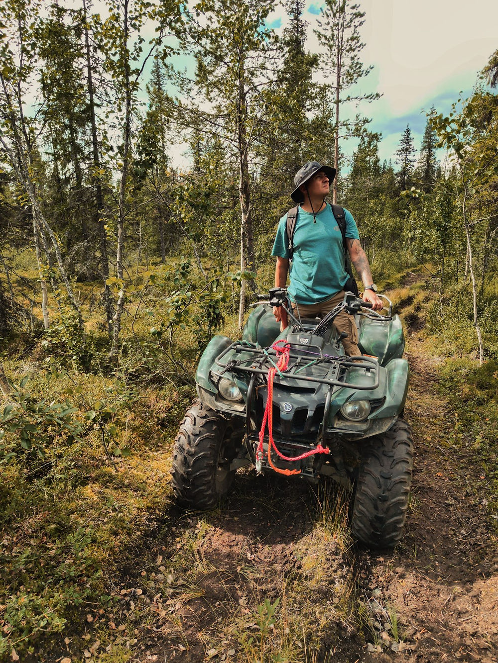 Hombre en ATV en sendero del bosque