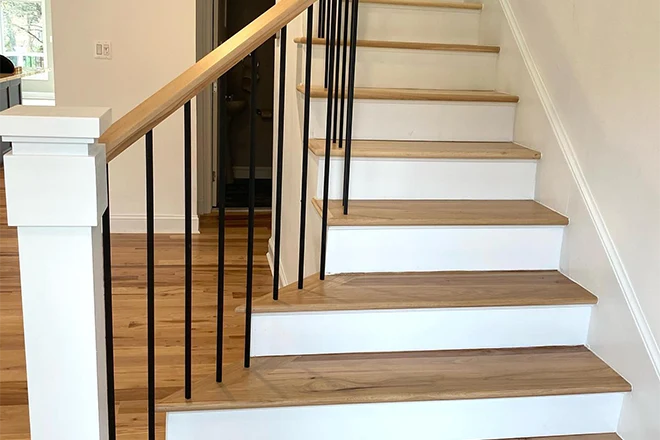 Light wood staircase with black balusters and white risers