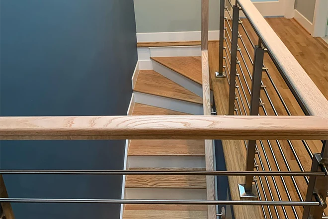Narrow wooden staircase next to a blue wall
