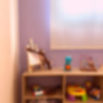 Foto do consultório: imagem de um móvel com brinquedos variados em sua superfície, parede lilás ao f