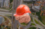 A human brain wearing an orange construction helmet is superimposed over an aerial view of a complex highway system. The image symbolizes the brain's ability to build new pathways and connections, much like constructing roads, highlighting the mental processes involved in learning and problem-solving.
