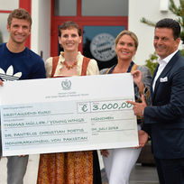Thomas Müller, Martina Münch-Nicolaidis, Patricia Poetis und Dr. Pantelis Christian Poetis mit einem Spendenscheck über 3.000 Euro für Kinder und Familien.