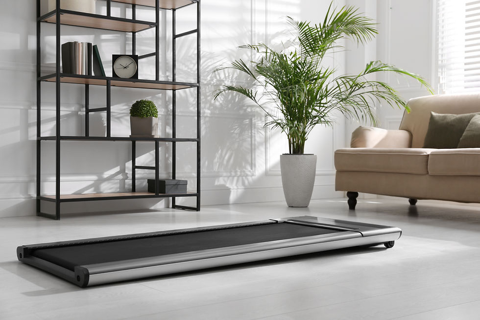 Sleek treadmill in a modern living room with light gray floors, beige sofa, large potted plant, and black shelf with books and a clock.