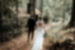 The bride and groom escape into the woods after their ceremony