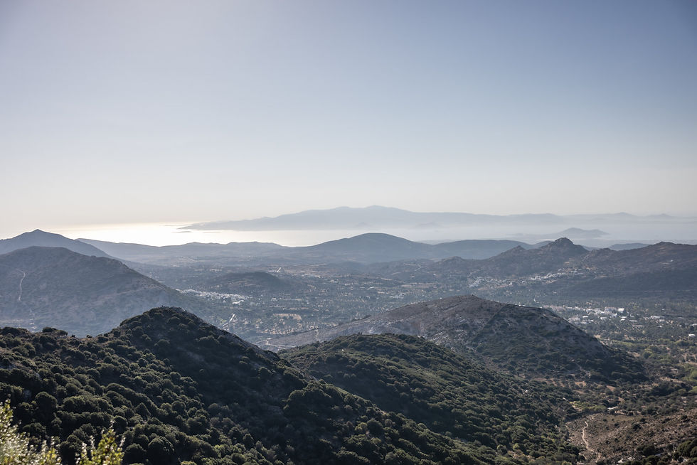 Eye-level view of whitewashed houses with bougainvillea in Naxos village