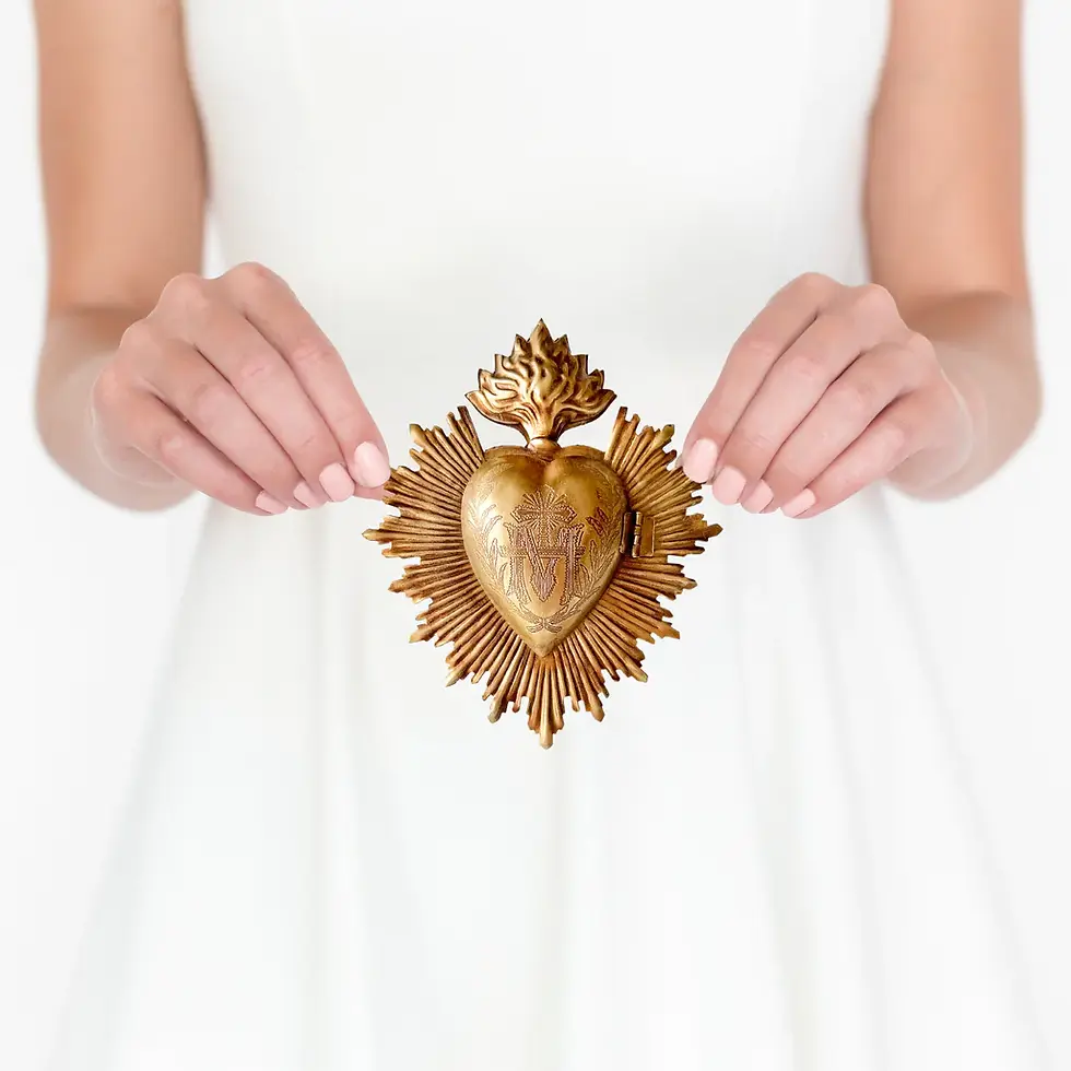 Hands holding a medium sized sacred heart ornament.
