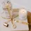 Thumbnail: gold candle care kit with wick trimmer, bell snuffer, and wick dipper.