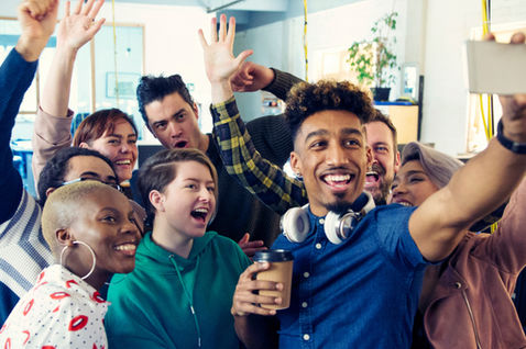 A lively group of coworkers gathers for a joyful selfie, capturing moments of fun and togetherness.