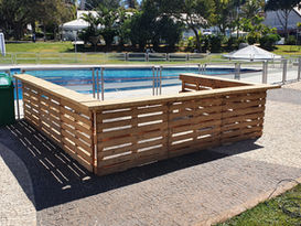 Biombo de palete cercando uma piscina em área externa