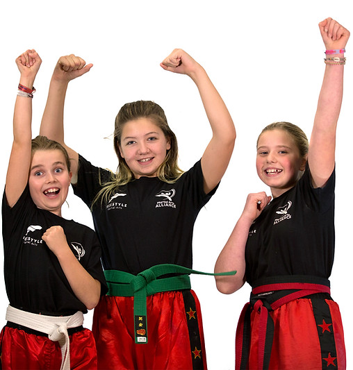 Three Biggleswade student girls confidently punching the air together during a martial art training class