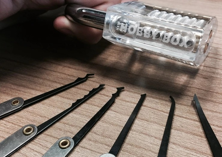 translucent padlock that says new hobby box with lock picks on table