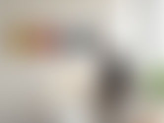 Donna in salotto osserva una parete con maschere teatrali che rappresentano emozioni, mentre accende un interruttore che illumina la maschera della rabbia