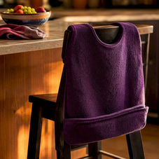 Adult bib laid on chair at dining table