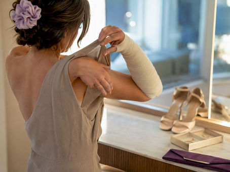 Wedding guest dressing with an arm cast