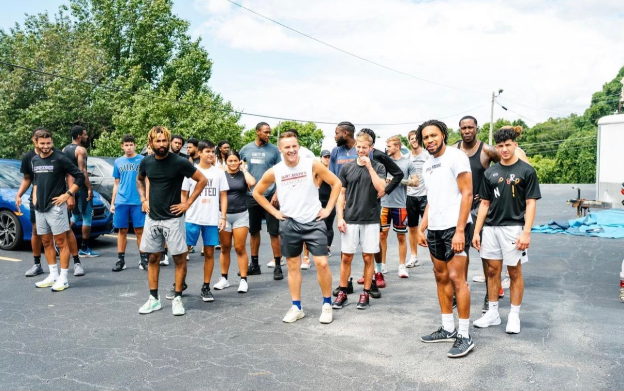 A wide group of JTM members lined up outside after a community workout