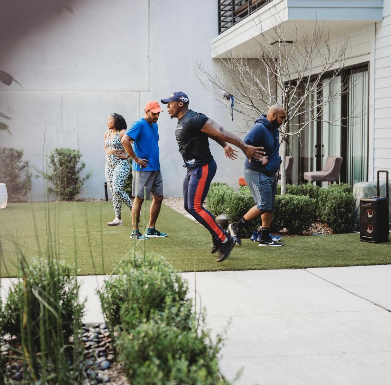 JTM members training outdoors together, one member skipping rope while the group cheers
