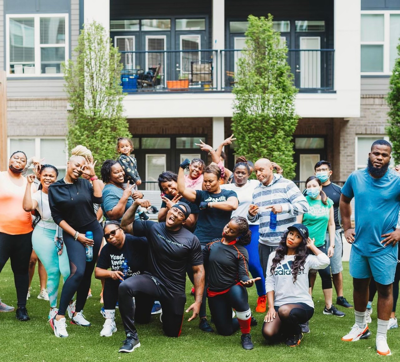 A large group of JTM Fitness Gym members celebrating together after an outdoor workout in Chamblee