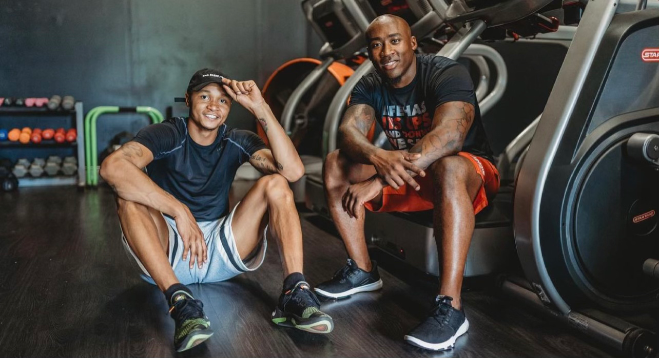 Two members catching their breath beside the cardio equipment at JTM Fitness Gym