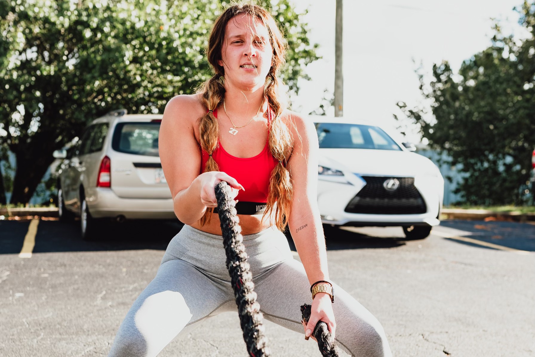 A JTM member driving battle ropes during an outdoor conditioning session