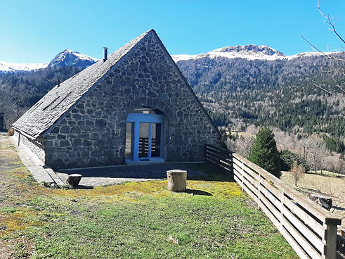 Terrasse de la chambre 3 du gîte, garde corps et vue sur les montagnes enneigées avec un grand soleil.