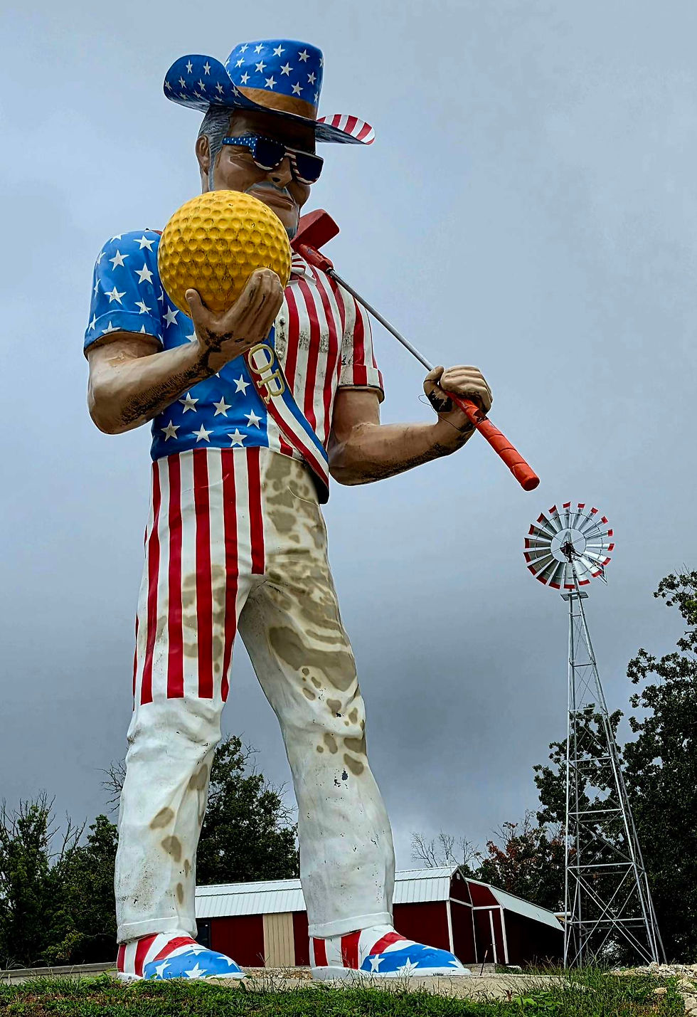 Giant Uncle Sam golfer statue holding a yellow ball