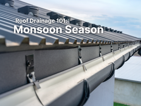 Roof gutter drains water into a puddle, with white text Roof Drainage 101: Monsoon Season on a rainy blue-gray background.