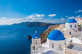 Whitewashed buildings beside the blue Aegean Sea in Greece