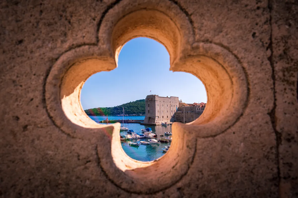 Dubrovnik harbour seen through a carved stone opening