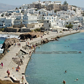 Naxos waterfront with whitewashed houses and turquoise Aegean Sea in Greece