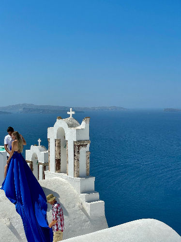 Couple enjoying sunset view over Santorini caldera Greece