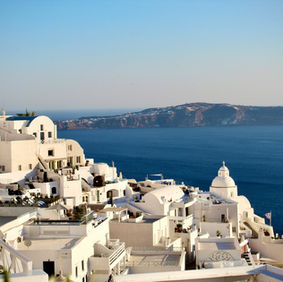 Whitewashed Greek island buildings overlooking the blue Aegean Sea