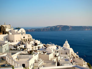 Whitewashed Greek island buildings overlooking the blue Aegean Sea