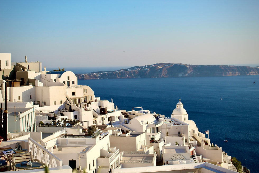 Whitewashed Greek island buildings overlooking the blue Aegean Sea