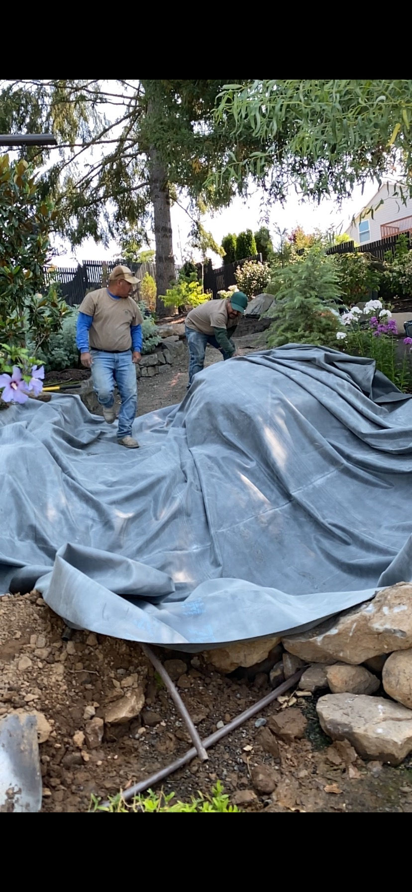 Water Feature liner being put down into hole where water feature will be installed.