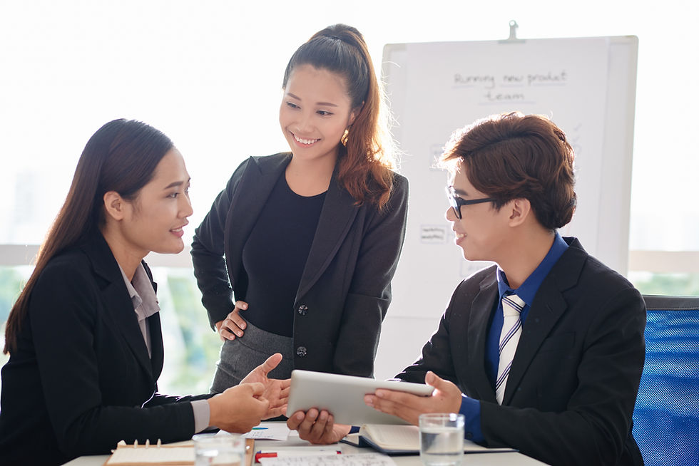 Three business professionals collaborating and sharing perspectives during a leadership meeting