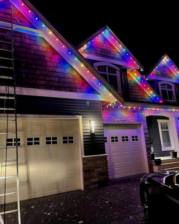 Multi-colour commercial grade LED holiday light display on house roofline