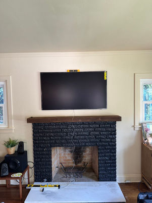 Living room makeover with wall-mounted TV above a freshly painted black fireplace