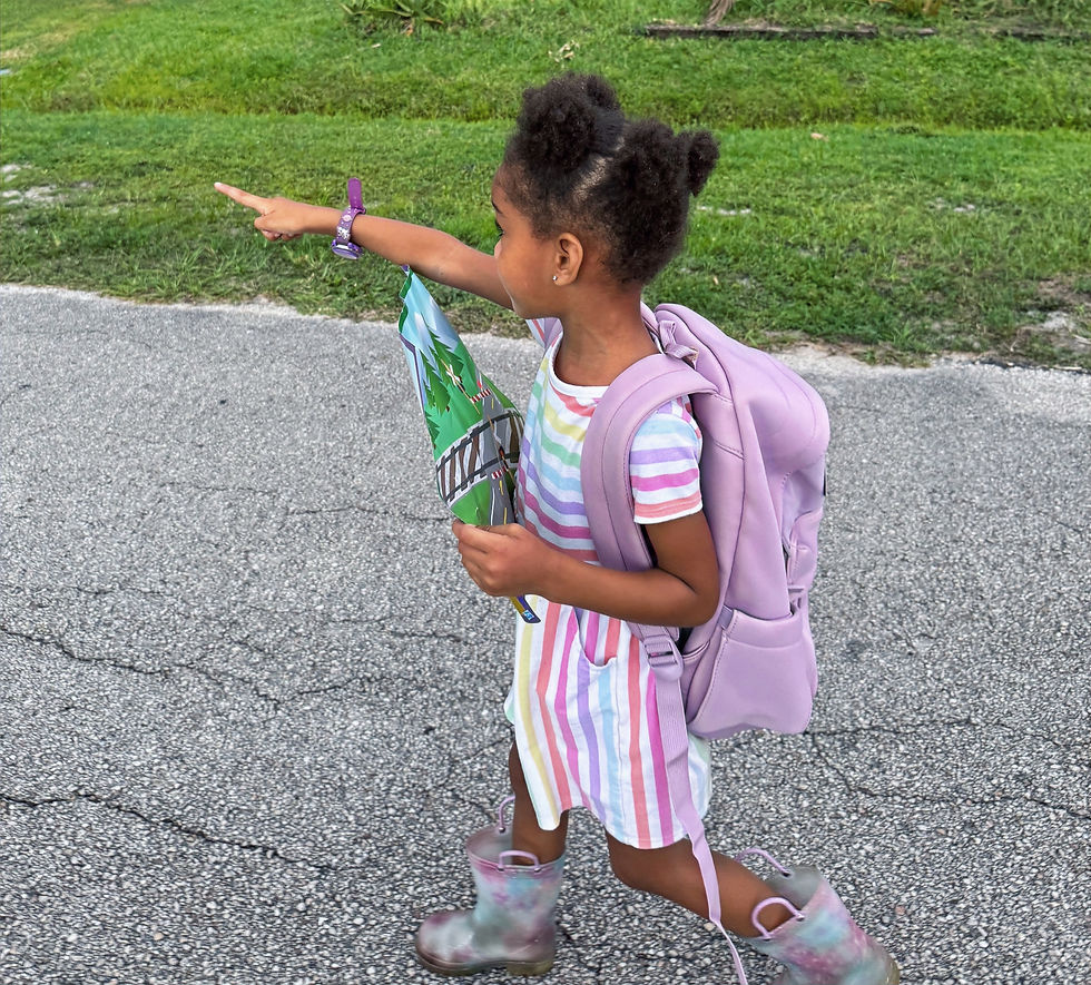 Little girl with rain boots, map, and back pack ready for an adventure