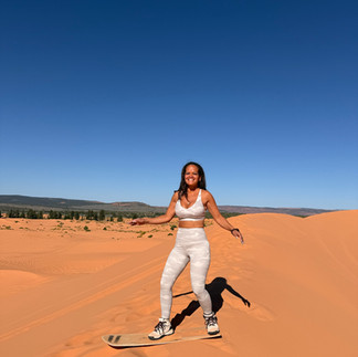 Woman Sandboarding at Coral Pink Sand Dunes