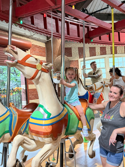 Little toddler girl riding the horse on the NYC Central Park Carousel