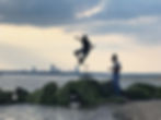 Kid jumping in the air over jetty