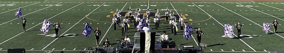 marching band and color guard perform on field 2023