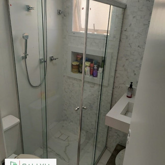 Box de canto com vidro transparente e perfil branco otimizado para espaços compactos com design elegante. Instalado pela Sallvia Vidros em São Paulo