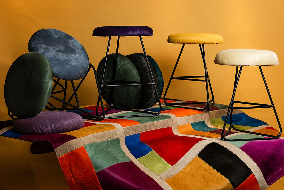 Bunte Hocker mit Fellbezügen auf buntem Teppich aus der Living-Kollektion von Hans Frauenschuh