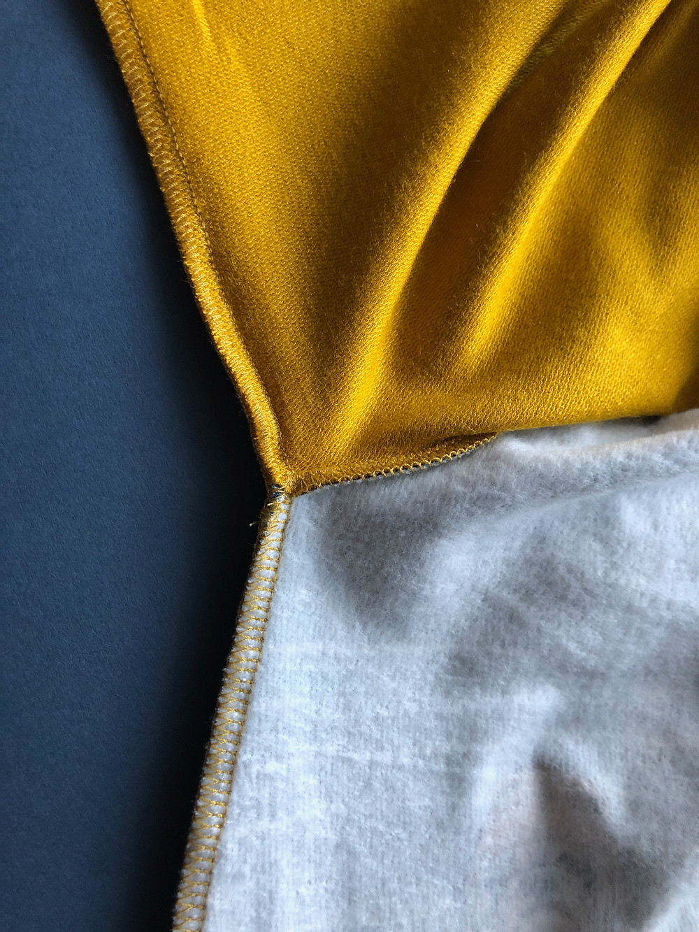 Gold overlocker thread on inside of baby romper
