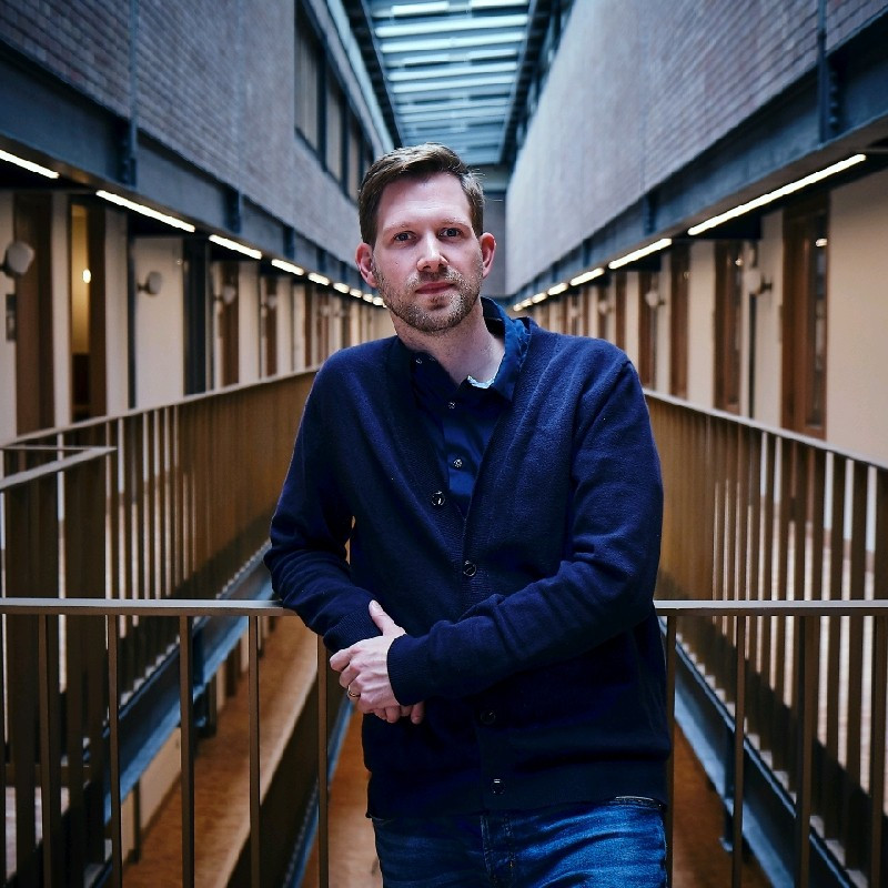 David Wing influencer marketing expert posing in front of stairwell in a blue jumper