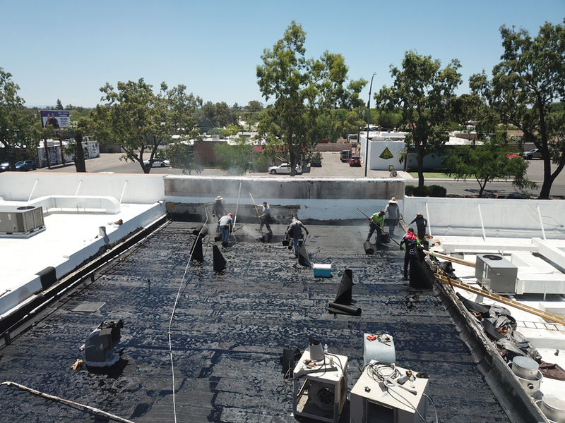 Crew installing a new flat roof system
